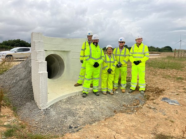 National Highways and contractor staff standing next to the printed headwall